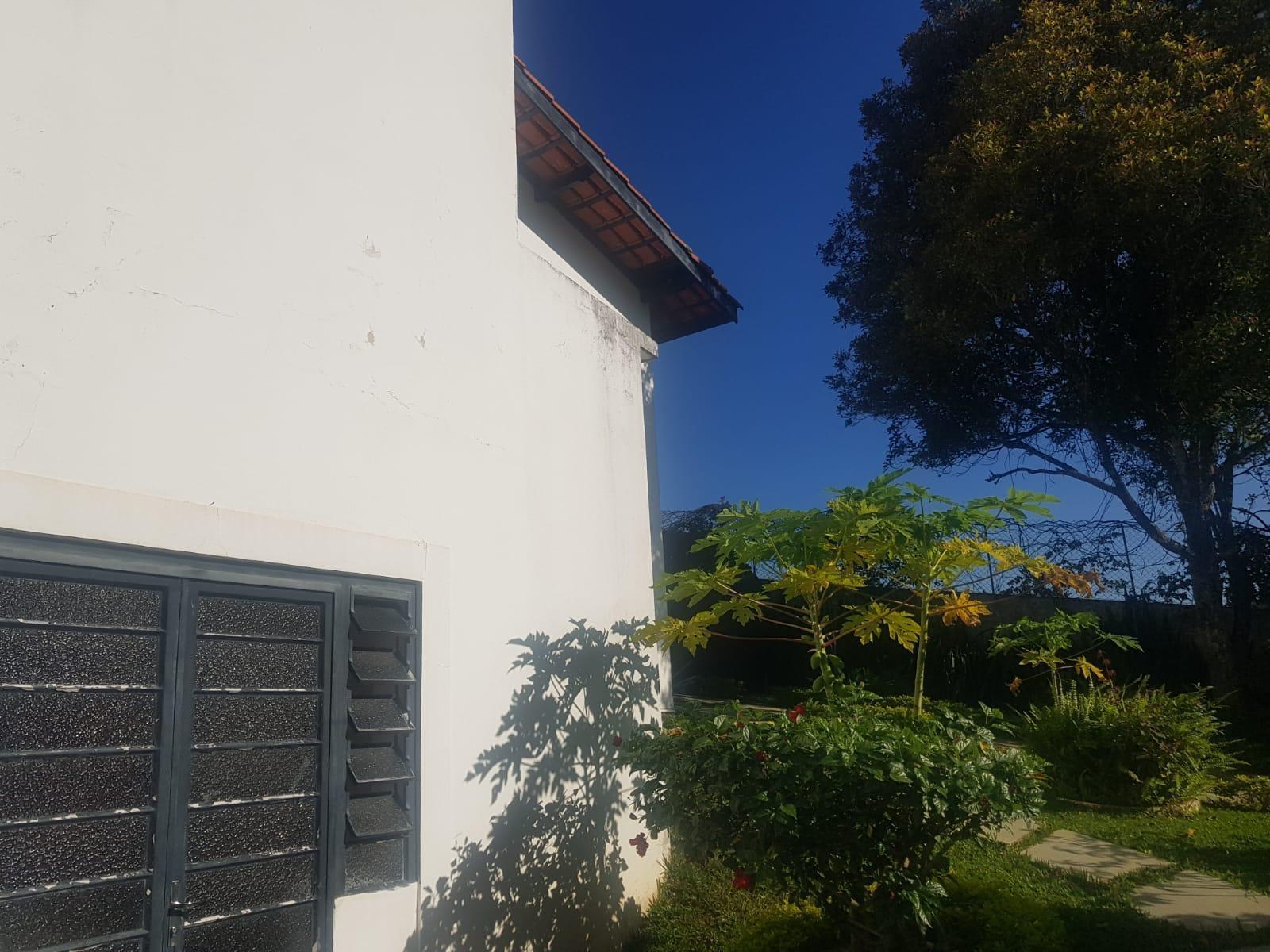 Casa branca com telhado de telhas sob céu azul